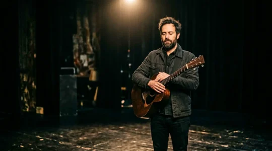 Musician standing still in spotlight moments before performance