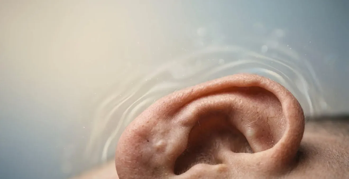 Close-up of an ear with sound waves visualized as gentle organic patterns