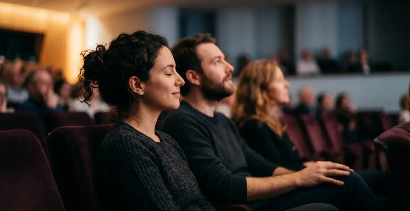 Close view of diverse concert audience members in warm ambient lighting showing focused attention and emotional engagement