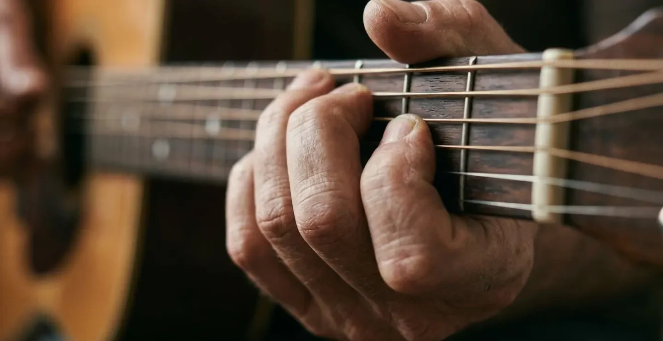 Close-up of guitarist hands on fretboard showing finger positioning and muscle memory patterns