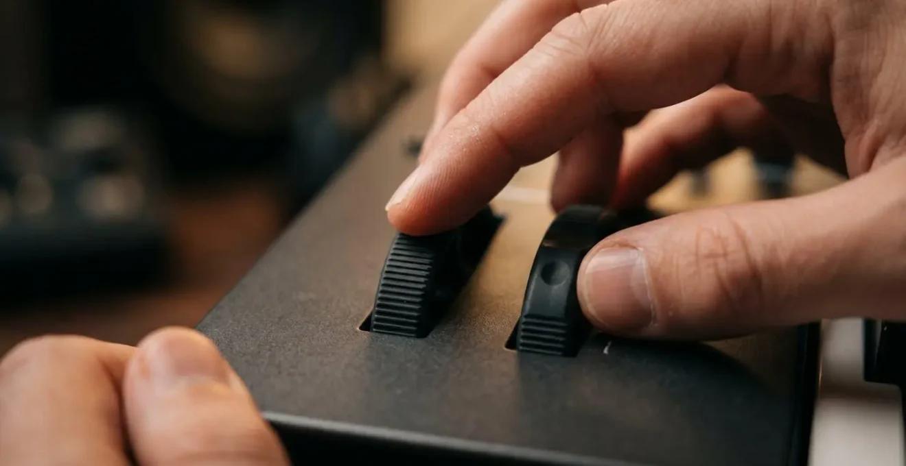 Macro close-up of hands adjusting synthesizer modulation controls during sound design session