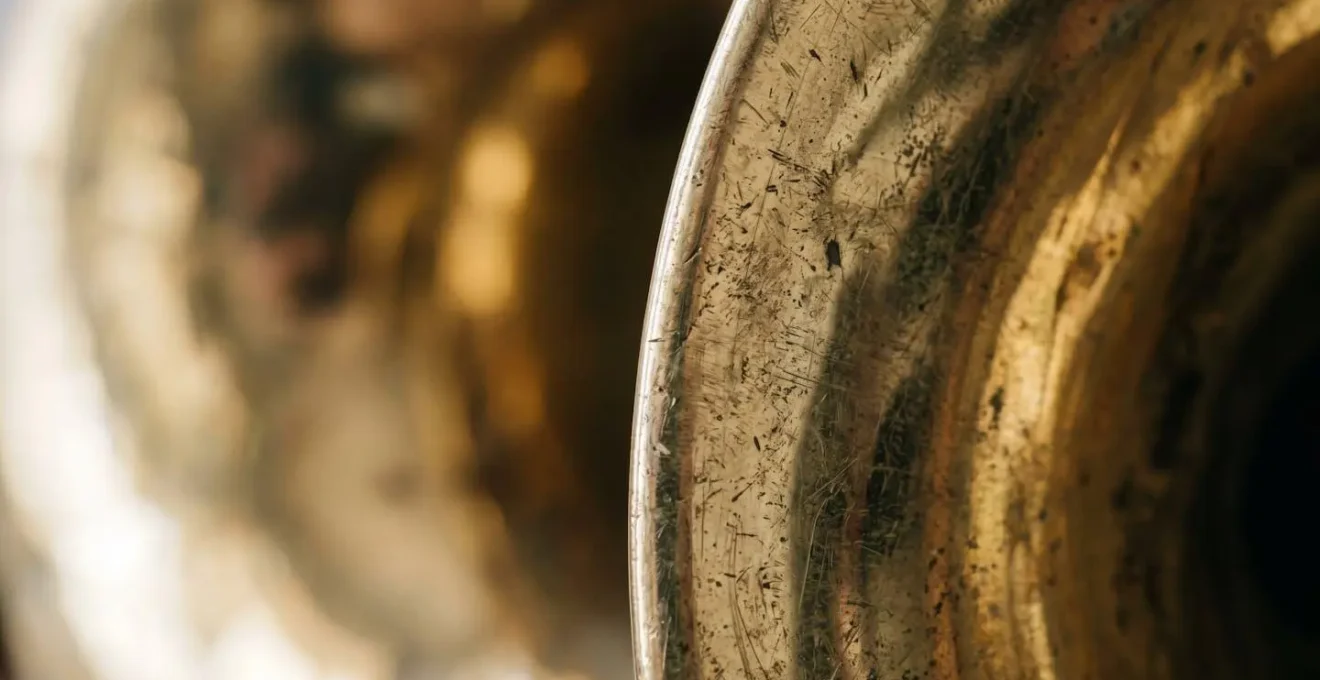 Extreme close-up detail of an orchestral instrument's surface, revealing intricate textures and craftsmanship