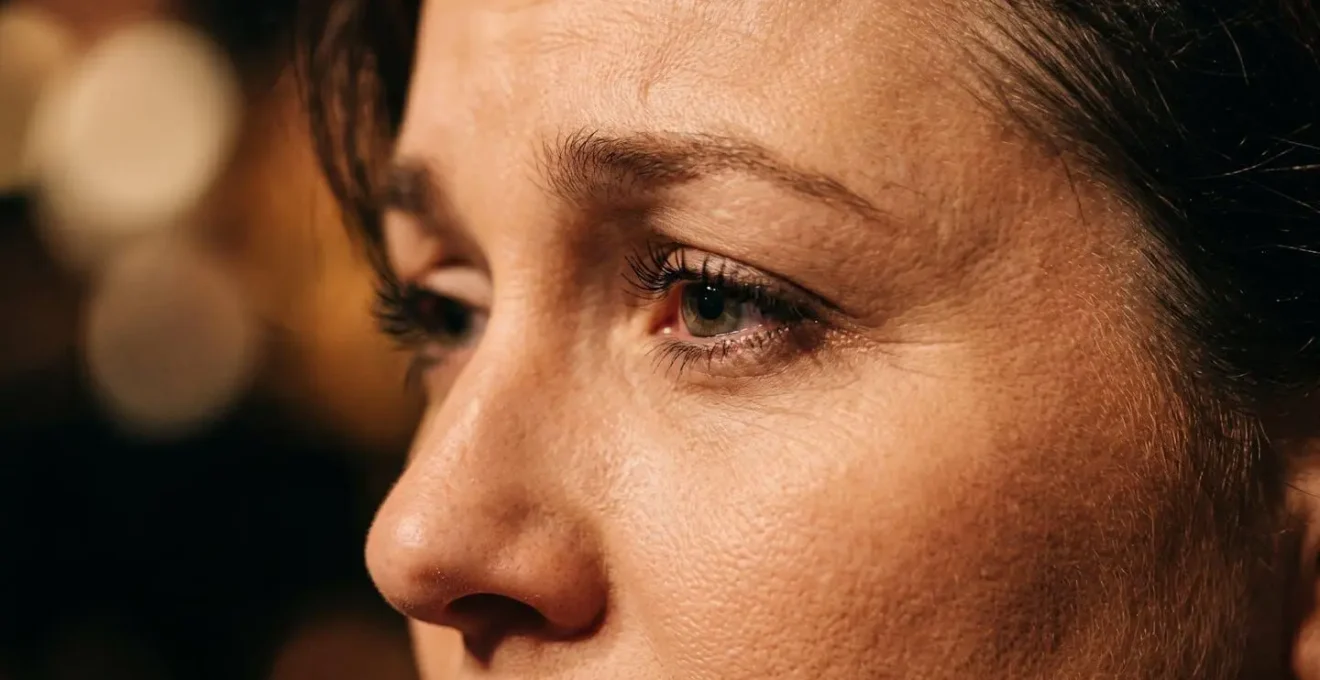 Macro detail of performer's facial expression showing subtle emotion and vulnerability during musical moment