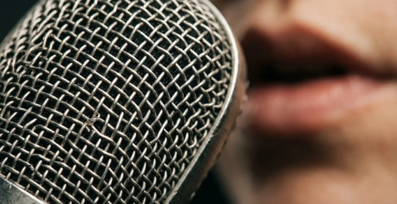 Extreme close-up of a microphone capsule showing proximity relationship with sound source through shallow depth of field