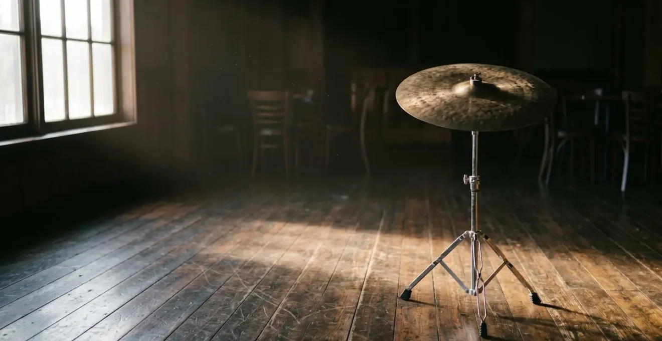 Environmental wide shot of a ride cymbal suspended in natural light showing the physical space and negative space around the instrument