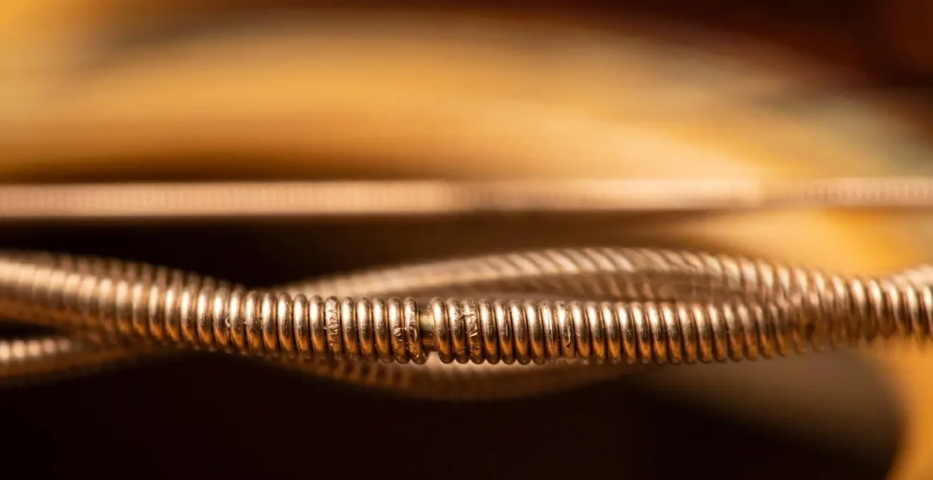 Extreme macro detail of guitar string vibrating, capturing the textural quality of a sustained note with vibrato